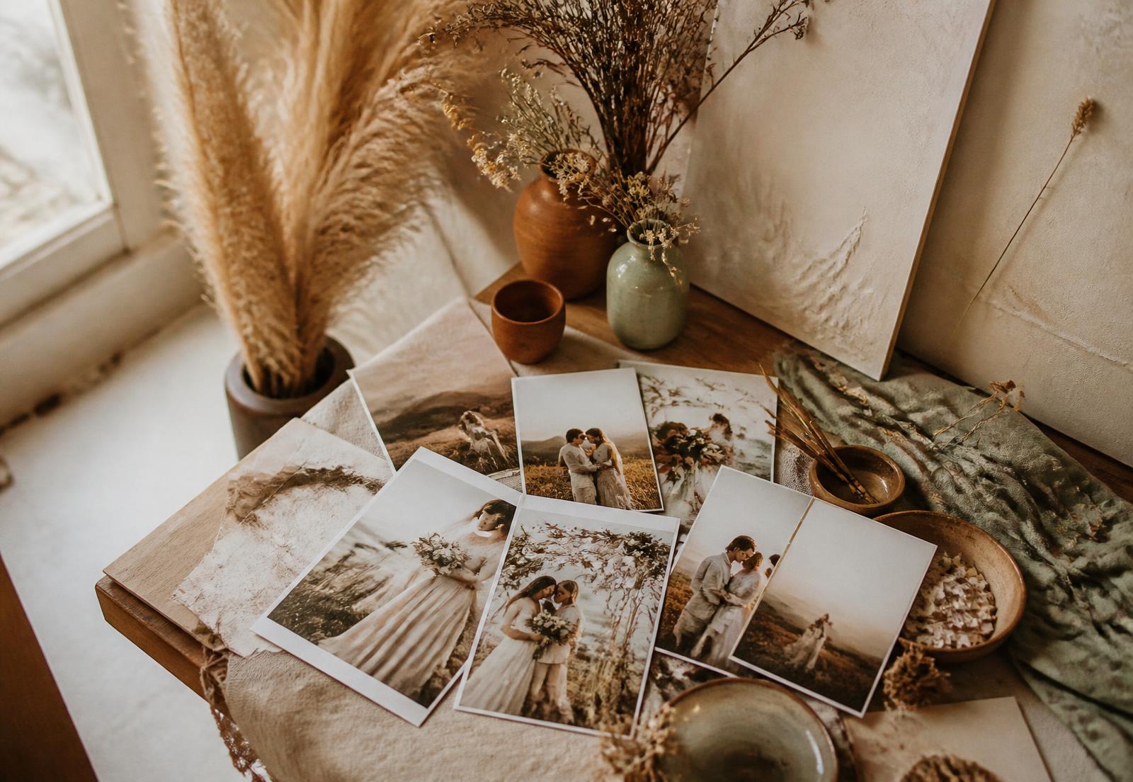 Boho-Studio-Tisch mit Trockenblumen und ausgedruckten Hochzeitsfotos
